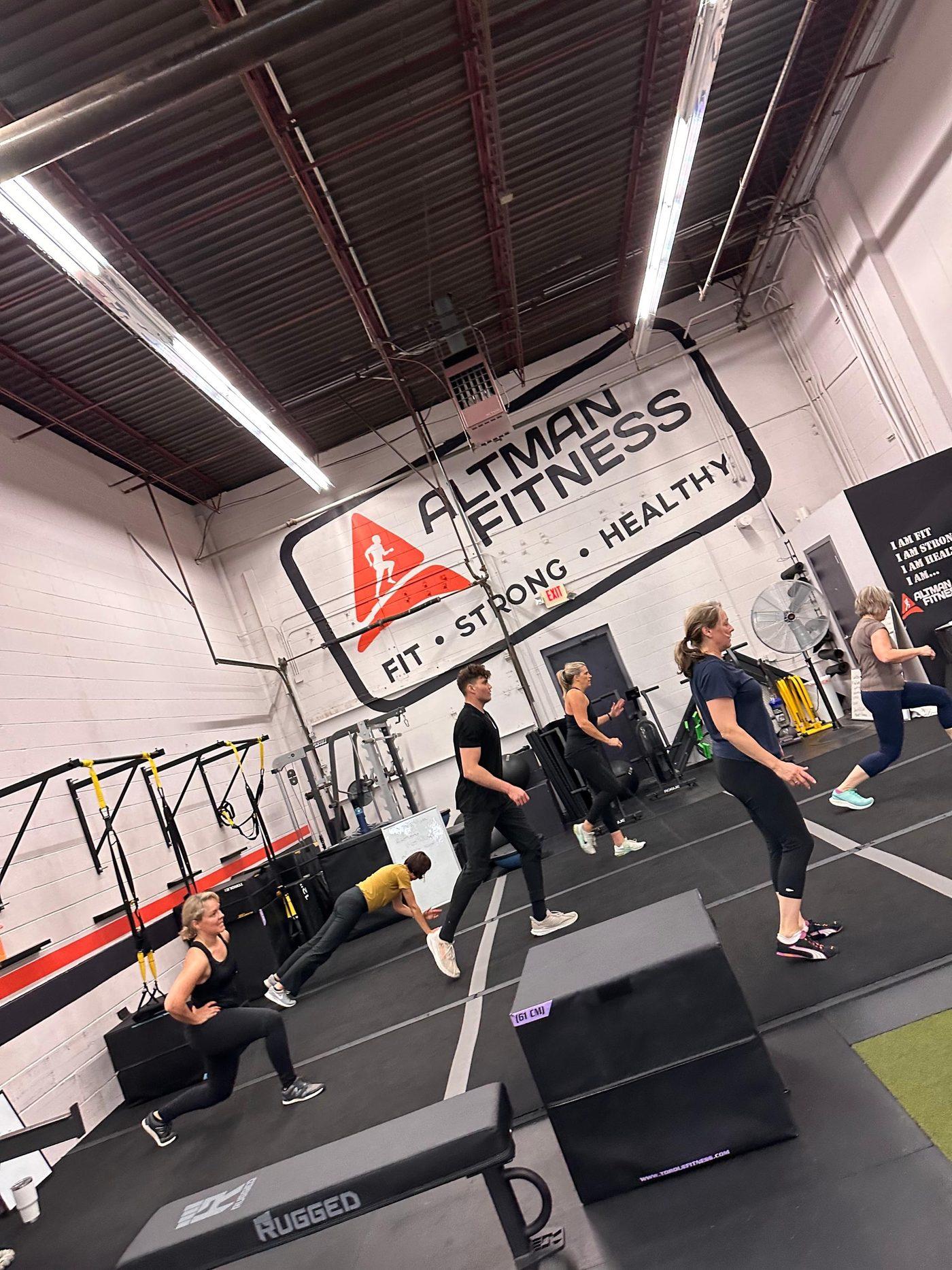 A coached class training under the Altman Fitness wall