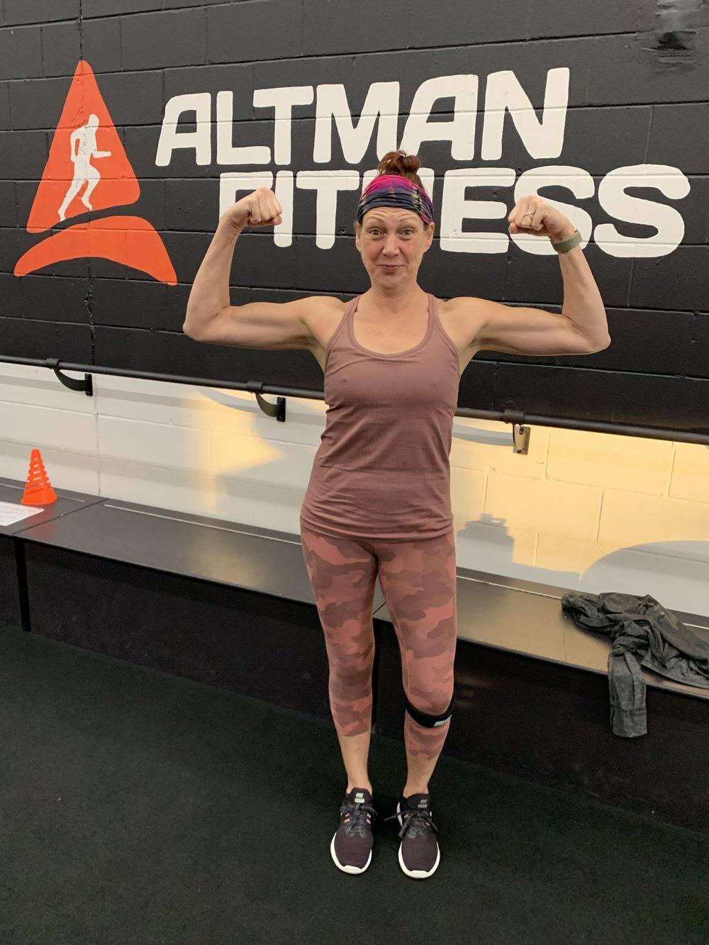 A member flexing in front of the Altman Fitness wall